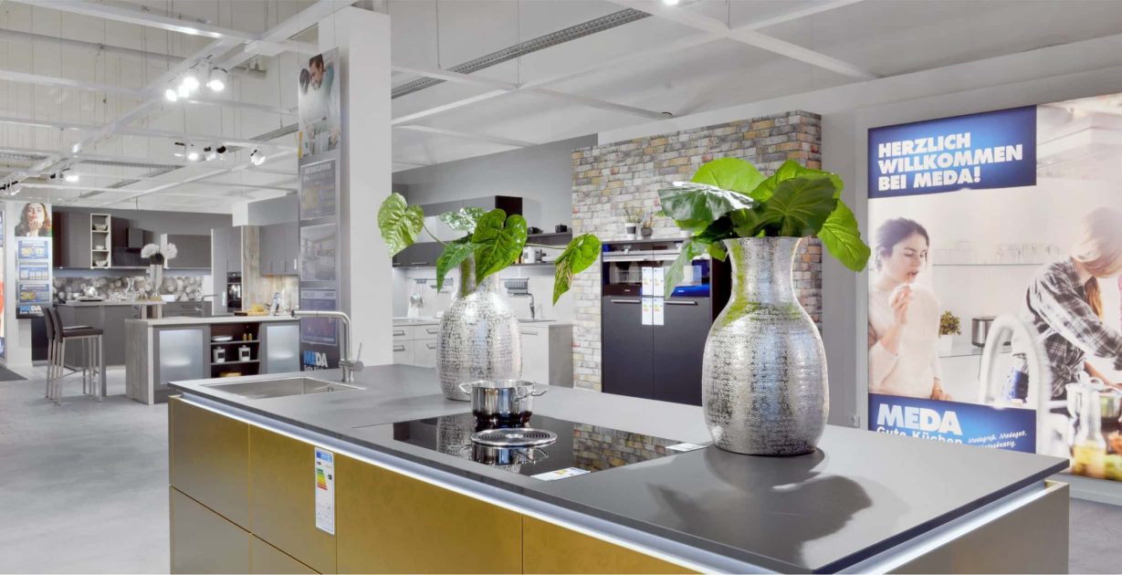 Moderne freistehende Küche mit Metallarbeitsplatte und holzfarbigen Schränken