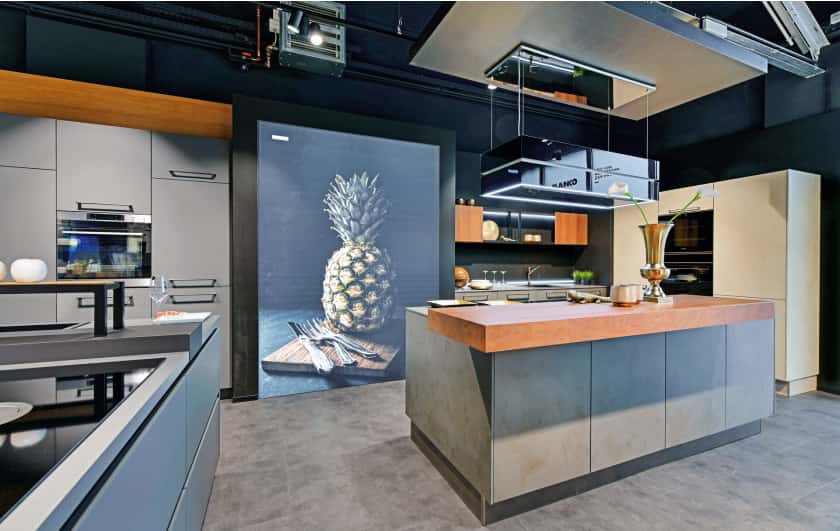 MEDA Küchenstudio Schwelm Innenansicht große Kücheninsel mit Holzerhebung